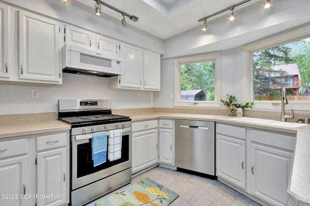 13521 Ebbtide Cir, Anchorage, AK 99516 - kitchen with appliances with stainless steel finishes, track lighting, a sink, light countertops, and white cabinets