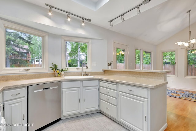 13521 Ebbtide Cir, Anchorage, AK 99516 - kitchen with stainless steel dishwasher, a sink, track lighting, light countertops, and white cabinetry