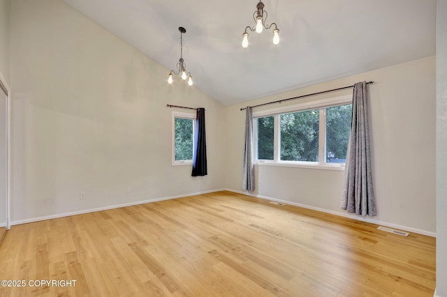 13521 Ebbtide Cir, Anchorage, AK 99516 - unfurnished room with a chandelier, vaulted ceiling, light wood-style flooring, and baseboards