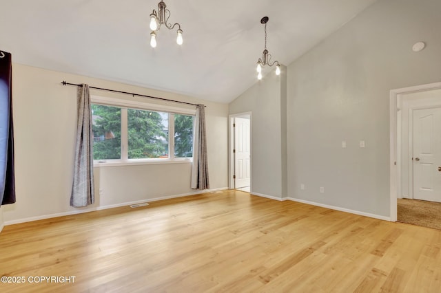 13521 Ebbtide Cir, Anchorage, AK 99516 - spare room with a chandelier, light wood finished floors, baseboards, and high vaulted ceiling