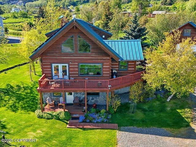58820 E End Rd, Homer, AK 99603 - back of house featuring a wooden deck, a lawn, a standing seam roof, metal roof, and log siding