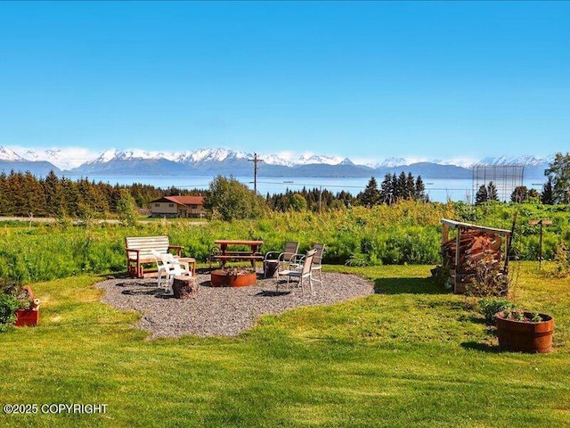 58820 E End Rd, Homer, AK 99603 - view of green lawn with an outdoor fire pit and a water and mountain view