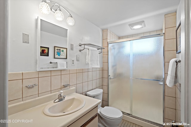 1310 G St, Anchorage, AK 99501 - bathroom featuring tile walls, a stall shower, toilet, vanity, and tile patterned floors