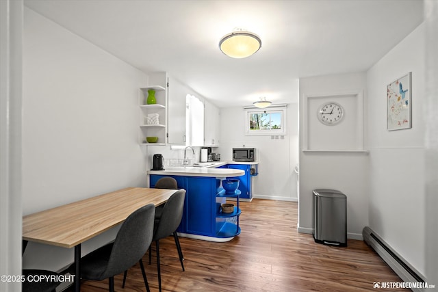 1310 G St, Anchorage, AK 99501 - kitchen featuring open shelves, baseboard heating, stainless steel microwave, wood finished floors, and white cabinetry