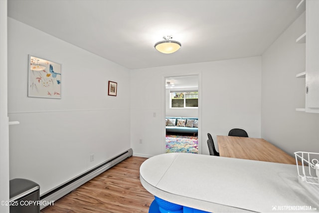 1310 G St, Anchorage, AK 99501 - home office featuring a baseboard heating unit, light wood-style floors, and baseboards