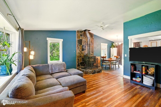 3470 W Wren St, Wasilla, AK 99623 - living room with wood finished floors, a ceiling fan, lofted ceiling, a wood stove, and a chandelier