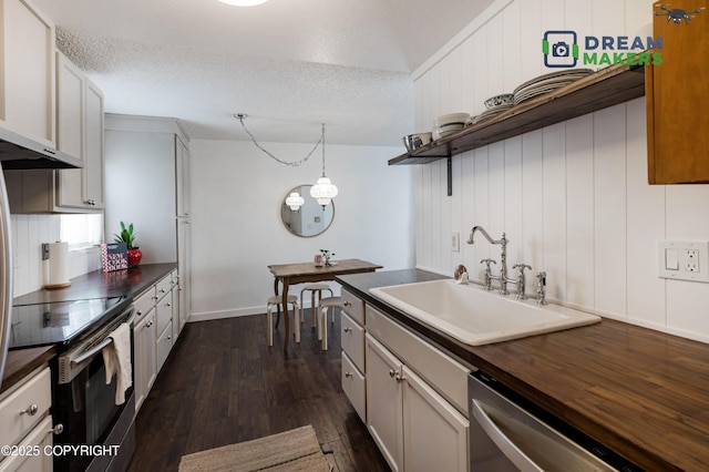 190 Grand Larry St Unit A-01, Anchorage, AK 99504 - kitchen with stainless steel appliances, dark wood-style flooring, wood counters, a textured ceiling, and wall chimney exhaust hood