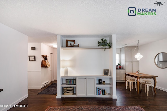 190 Grand Larry St Unit A-01, Anchorage, AK 99504 - living area with a baseboard radiator, dark wood-style flooring, a textured ceiling, and a wainscoted wall