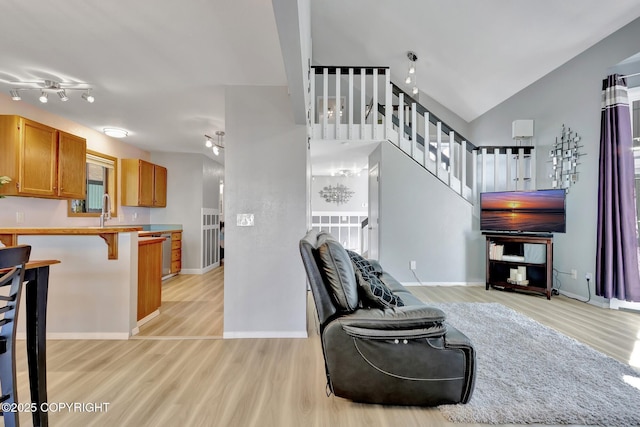 3370 Chaparral Cir, Anchorage, AK 99502 - living area featuring light wood-style flooring, stairway, vaulted ceiling, and baseboards