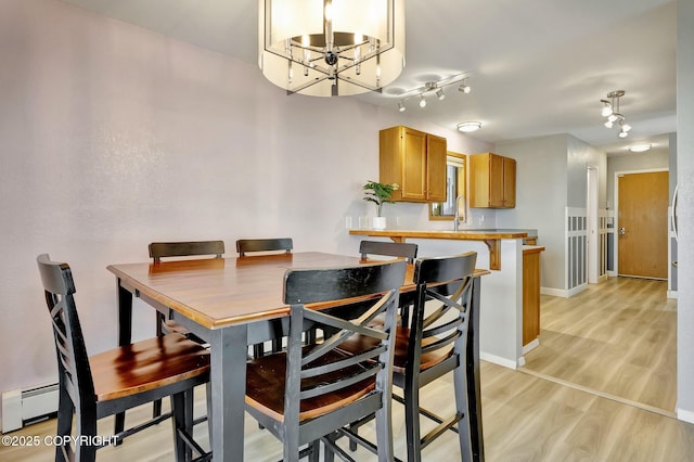3370 Chaparral Cir, Anchorage, AK 99502 - dining room with baseboards, light wood-style flooring, a chandelier, and baseboard heating