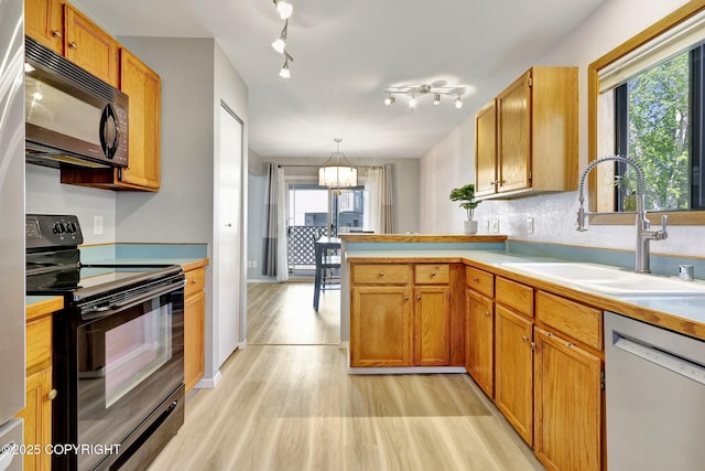 3370 Chaparral Cir, Anchorage, AK 99502 - kitchen featuring black appliances, a sink, light wood-style floors, a chandelier, and a peninsula
