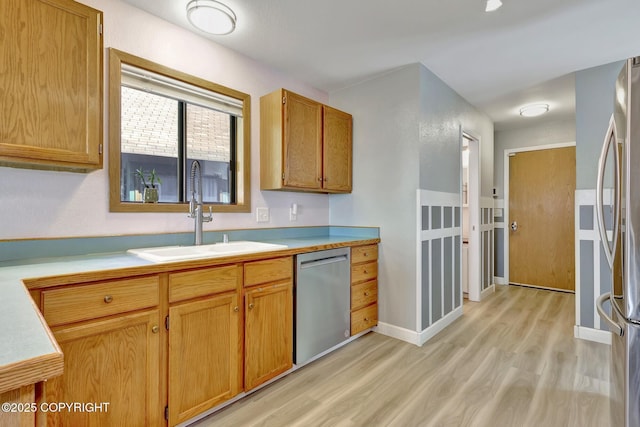 3370 Chaparral Cir, Anchorage, AK 99502 - kitchen with stainless steel appliances, a sink, light wood finished floors, light countertops, and baseboards