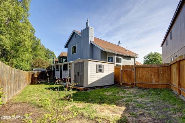 3370 Chaparral Cir, Anchorage, AK 99502 - back of property featuring a chimney, a gate, and an outdoor structure