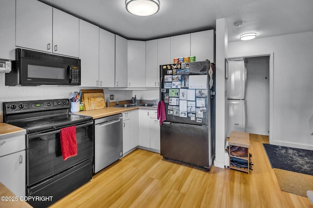 824 O Pl, Anchorage, AK 99501 - kitchen featuring black appliances, light wood-style floors, white cabinetry, and light countertops