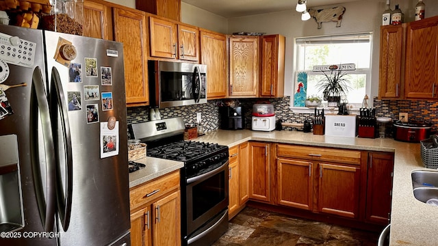 7191 S Yohn Bay Pl, Wasilla, AK 99623 - kitchen featuring appliances with stainless steel finishes, decorative backsplash, light countertops, and brown cabinets