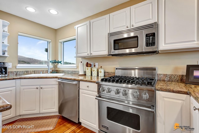 16971 Mount Mckinley View Dr, Anchorage, AK 99516 - kitchen with stainless steel appliances, a sink, white cabinets, light wood finished floors, and recessed lighting