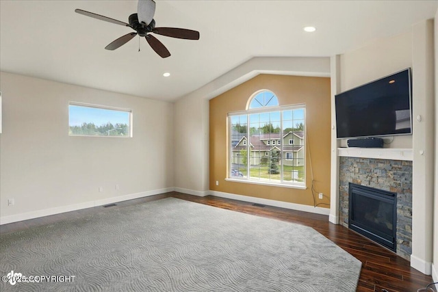 5846 Grand Teton Loop, Anchorage, AK 99502 - unfurnished living room with vaulted ceiling, wood finished floors, ceiling fan, a stone fireplace, and baseboards