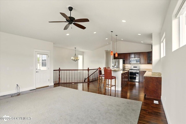 5846 Grand Teton Loop, Anchorage, AK 99502 - kitchen with stainless steel appliances, vaulted ceiling, dark brown cabinetry, dark wood-type flooring, and baseboards