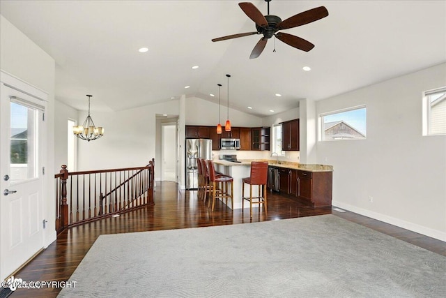 5846 Grand Teton Loop, Anchorage, AK 99502 - kitchen with appliances with stainless steel finishes, dark wood-type flooring, vaulted ceiling, light countertops, and a kitchen island
