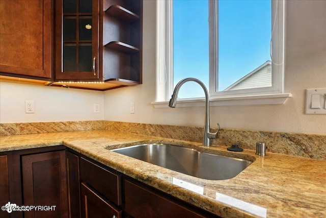 5846 Grand Teton Loop, Anchorage, AK 99502 - kitchen with a sink, glass insert cabinets, light stone countertops, and dark brown cabinets