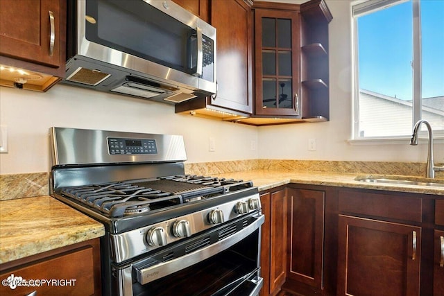 5846 Grand Teton Loop, Anchorage, AK 99502 - kitchen with appliances with stainless steel finishes, a sink, glass insert cabinets, and light stone countertops