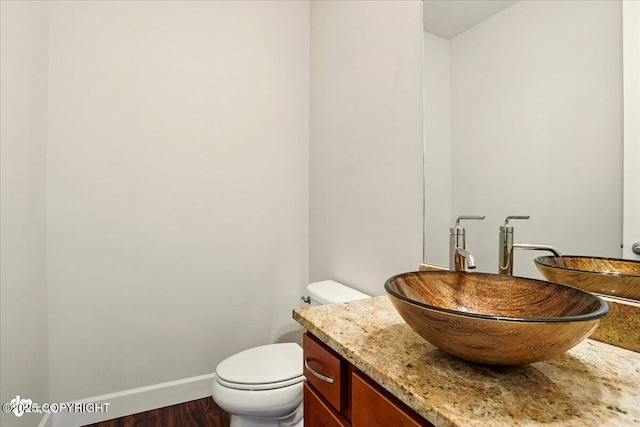 5846 Grand Teton Loop, Anchorage, AK 99502 - half bathroom featuring vanity, toilet, baseboards, and wood finished floors