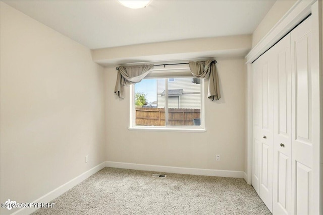 5846 Grand Teton Loop, Anchorage, AK 99502 - unfurnished bedroom featuring a closet, baseboards, and carpet flooring