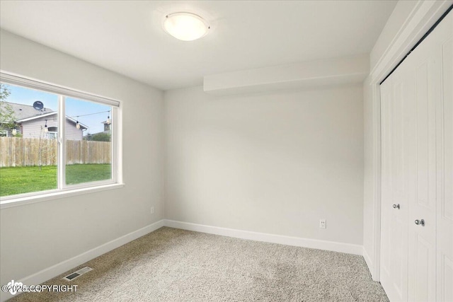 5846 Grand Teton Loop, Anchorage, AK 99502 - unfurnished bedroom featuring a closet, light carpet, and baseboards
