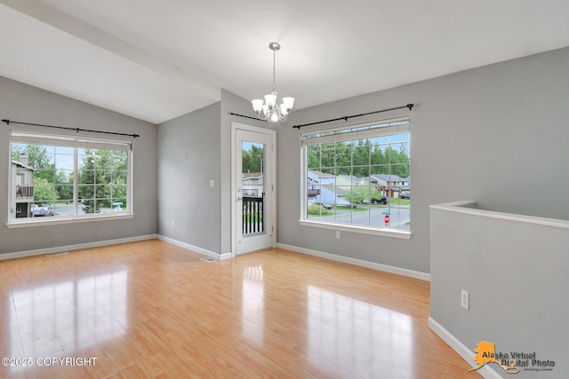 17480 Beaujolais Cir, Eagle River, AK 99577 - empty room with a chandelier, wood finished floors, baseboards, and lofted ceiling