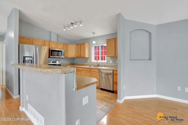17480 Beaujolais Cir, Eagle River, AK 99577 - kitchen featuring stainless steel appliances, a sink, light countertops, light wood-style floors, and vaulted ceiling