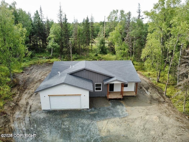 680 Wortham Ave, Kenai, AK 99611 - view of front of home featuring roof with shingles, a porch, and a view of trees