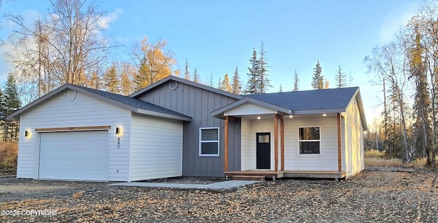 680 Wortham Ave, Kenai, AK 99611 - view of front facade with board and batten siding, a garage, gravel driveway, and a shingled roof