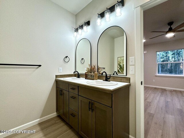 680 Wortham Ave, Kenai, AK 99611 - full bath featuring double vanity, wood finished floors, ceiling fan, and baseboards