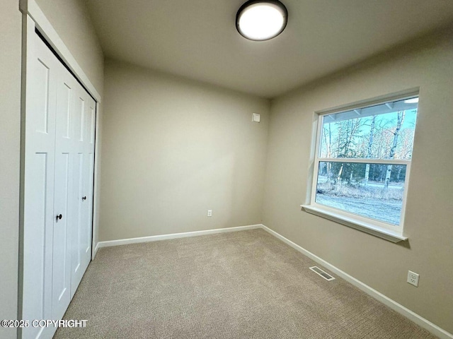 680 Wortham Ave, Kenai, AK 99611 - unfurnished bedroom with a closet, baseboards, and carpet floors