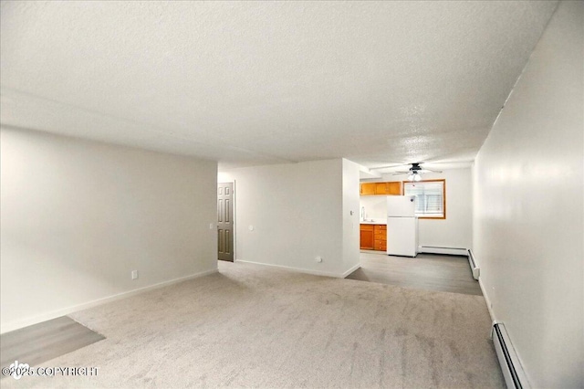 3962 Reka Dr # C1, Anchorage, AK 99508 - unfurnished living room with a textured ceiling, light carpet, baseboard heating, baseboards, and a baseboard heating unit