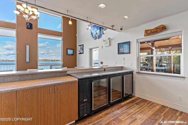 5322 S Big Lake Rd, Big Lake, AK 99652 - indoor bar featuring wood finished floors, wine cooler, a chandelier, recessed lighting, and a high ceiling