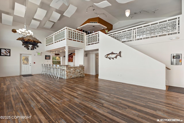 5322 S Big Lake Rd, Big Lake, AK 99652 - unfurnished living room with high vaulted ceiling, hardwood / wood-style floors, rail lighting, and a chandelier