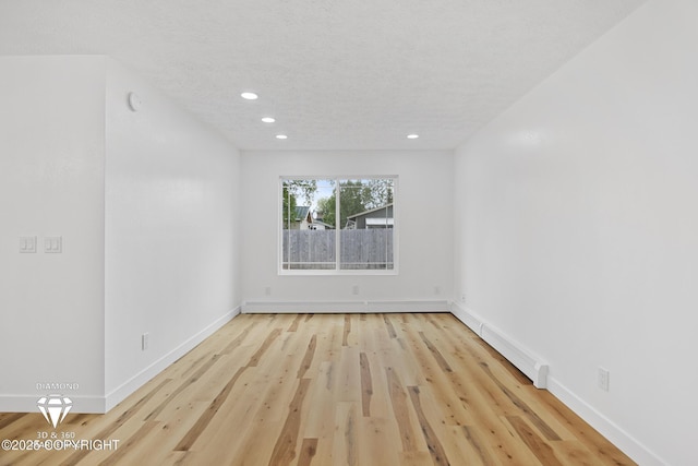 10108 Thimble Berry Dr, Anchorage, AK 99515 - spare room featuring recessed lighting, wood finished floors, baseboards, baseboard heating, and a textured ceiling