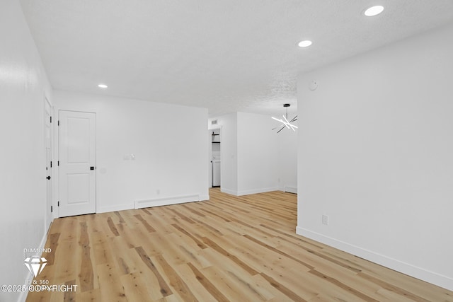 10108 Thimble Berry Dr, Anchorage, AK 99515 - spare room with a chandelier, a baseboard radiator, light wood finished floors, baseboards, and recessed lighting