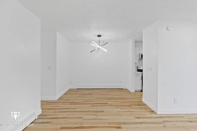 10108 Thimble Berry Dr, Anchorage, AK 99515 - unfurnished room featuring a chandelier, baseboard heating, light wood finished floors, baseboards, and a textured ceiling