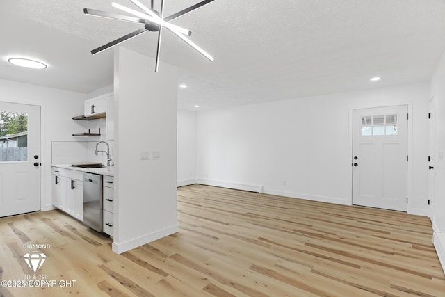 10108 Thimble Berry Dr, Anchorage, AK 99515 - kitchen with stainless steel dishwasher, a sink, light wood finished floors, white cabinets, and recessed lighting