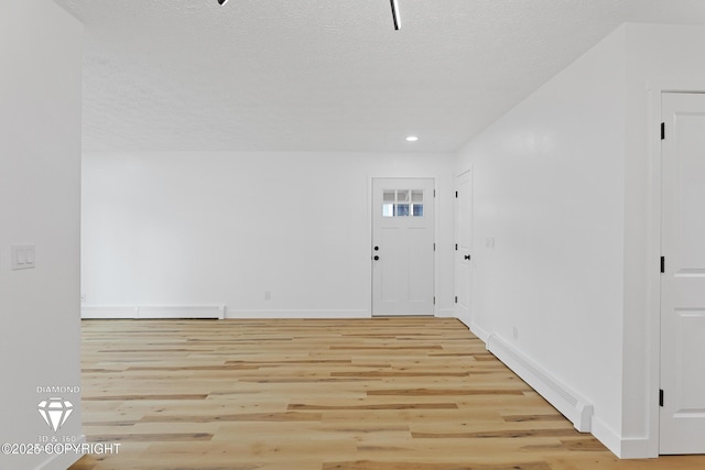 10108 Thimble Berry Dr, Anchorage, AK 99515 - foyer entrance featuring a baseboard radiator, light wood finished floors, baseboards, recessed lighting, and a textured ceiling