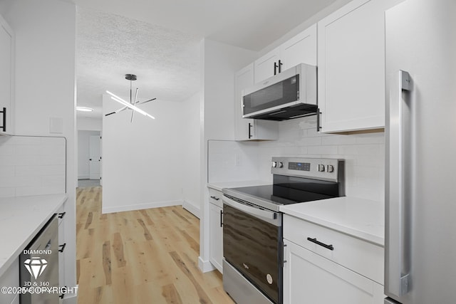 10108 Thimble Berry Dr, Anchorage, AK 99515 - kitchen with stainless steel appliances, light wood-style flooring, white cabinetry, light countertops, and a textured ceiling