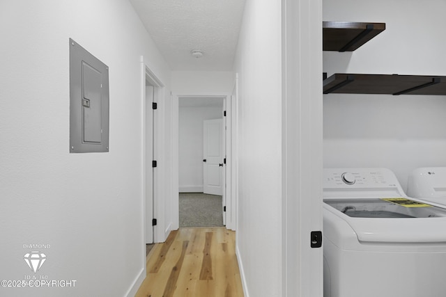 10108 Thimble Berry Dr, Anchorage, AK 99515 - laundry area featuring electric panel, light wood finished floors, baseboards, and a textured ceiling