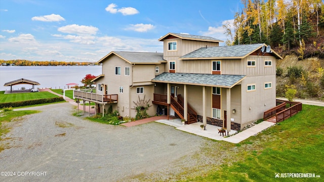 5322 S Big Lake Rd, Big Lake, AK 99623 - rear view of house with a shingled roof, a water view, a lawn, and driveway