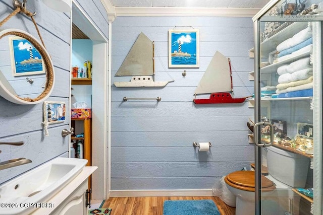 5411 Honeysuckle Ln, Wasilla, AK 99654 - bathroom with wood finished floors, vanity, toilet, baseboards, and crown molding