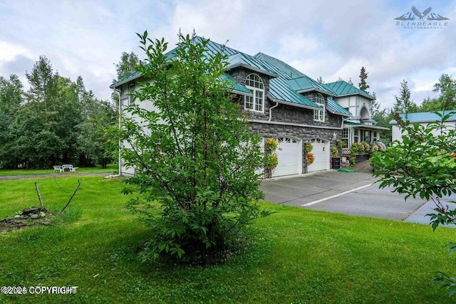 5411 Honeysuckle Ln, Wasilla, AK 99654 - view of front of property featuring a standing seam roof, stone siding, an attached garage, a front yard, and concrete driveway