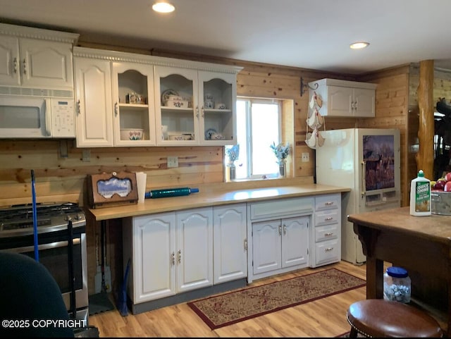 5411 Honeysuckle Ln, Wasilla, AK 99654 - kitchen with white appliances, wood walls, white cabinets, glass insert cabinets, and recessed lighting