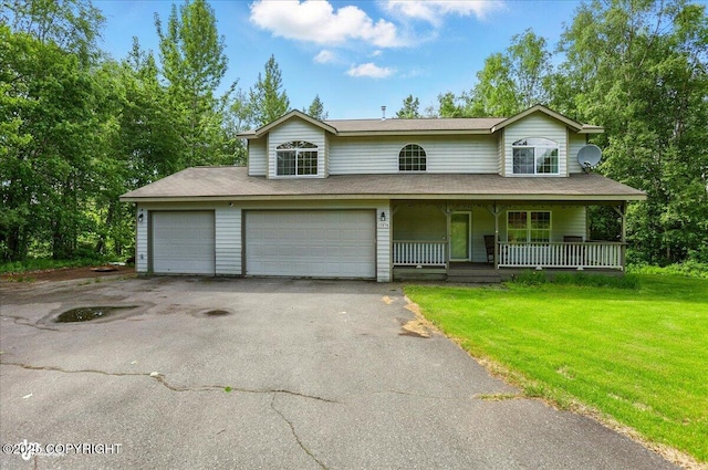 22030 Birch Creek Dr, Chugiak, AK 99567 - view of front of house with asphalt driveway, covered porch, a front lawn, a shingled roof, and a garage