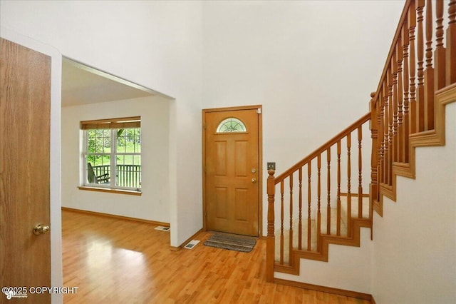 22030 Birch Creek Dr, Chugiak, AK 99567 - entrance foyer featuring wood finished floors, stairs, a towering ceiling, and baseboards